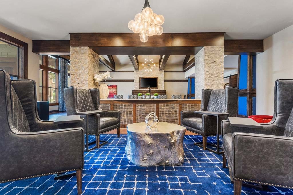 a lobby of a hotel with chairs and a table