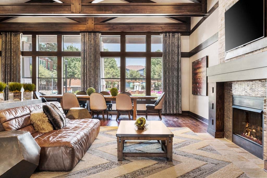 a large living room with a leather couch and a fireplace