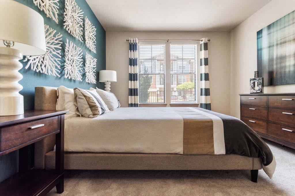 a bedroom with a bed and a painting on the wall