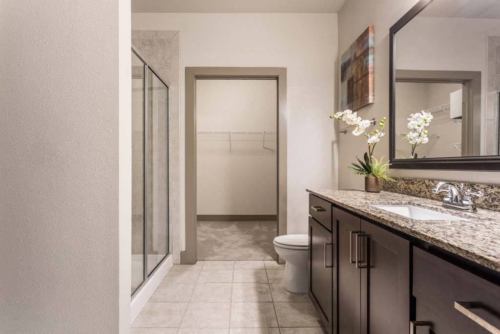 a bathroom with a shower and a sink and a toilet