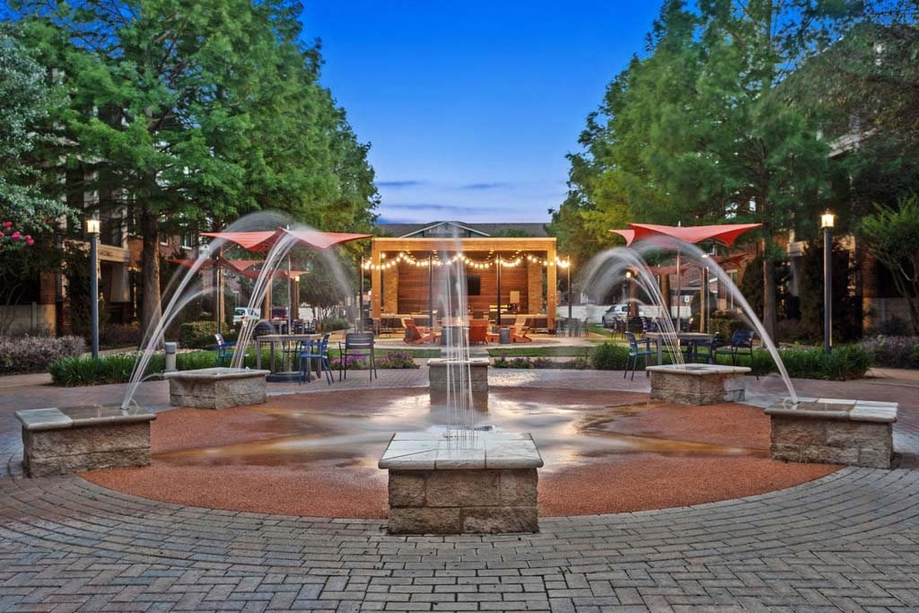 a fountain in the middle of a park at night