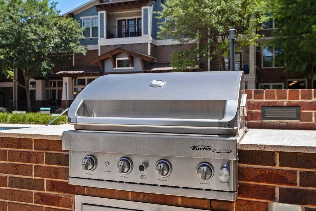 a stainless steel grill on top of a brick wall