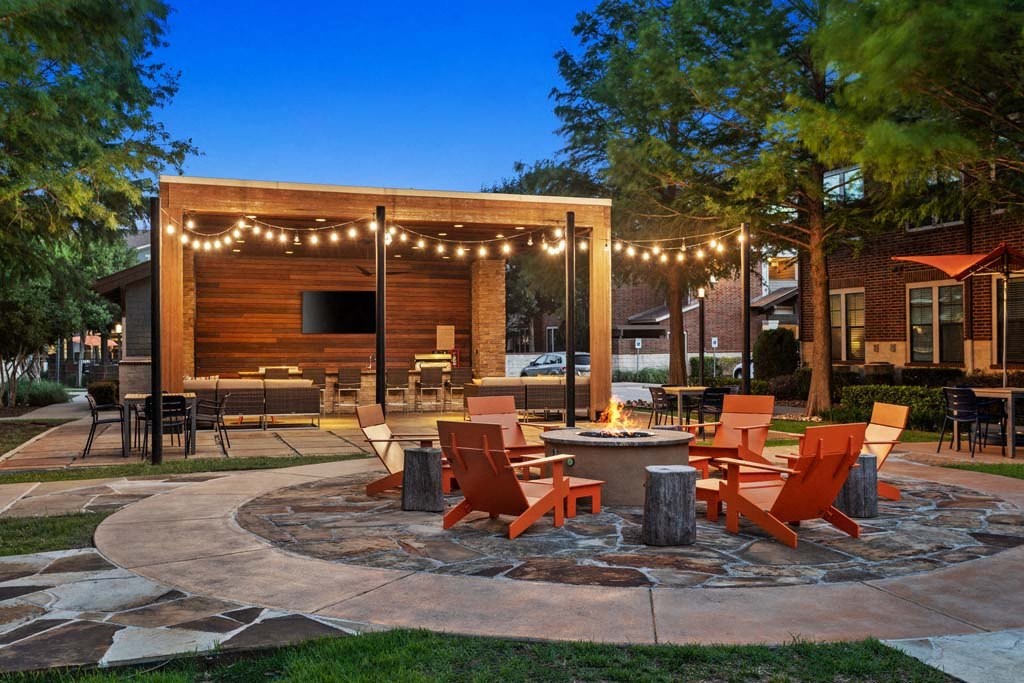 a patio with tables and chairs and a fire pit