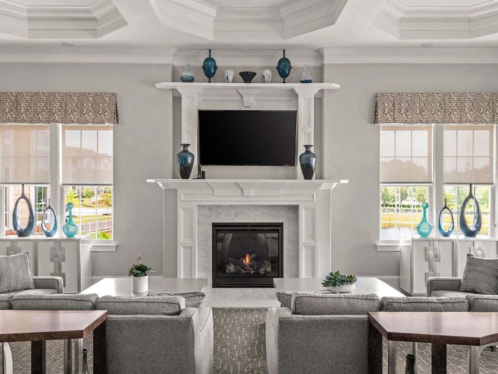 A living room with a fireplace and grey couches.