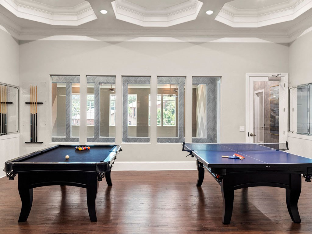A pool table in a room with a window.