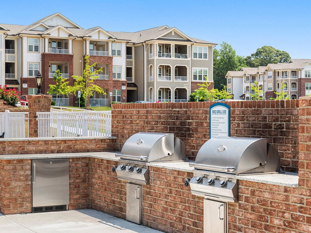 A wall of grills is in front of apartment buildings.