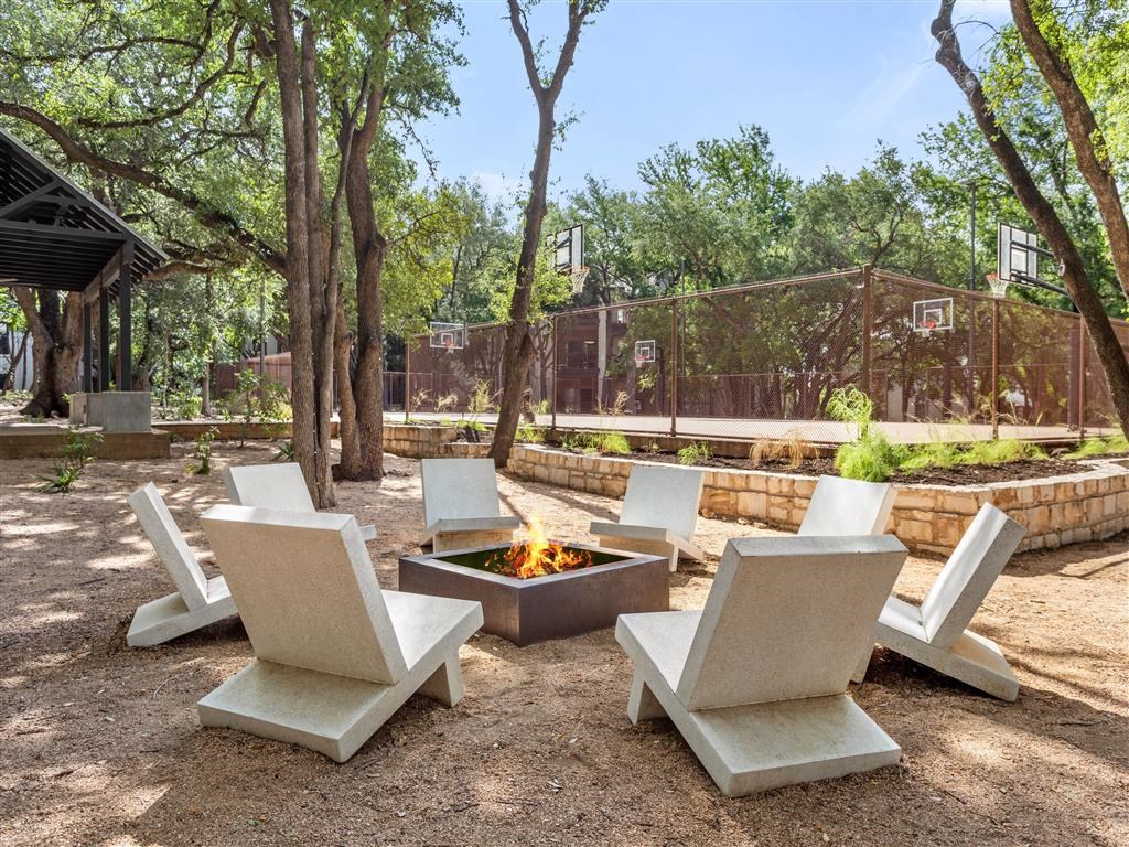 a group of white chairs around a fire pit