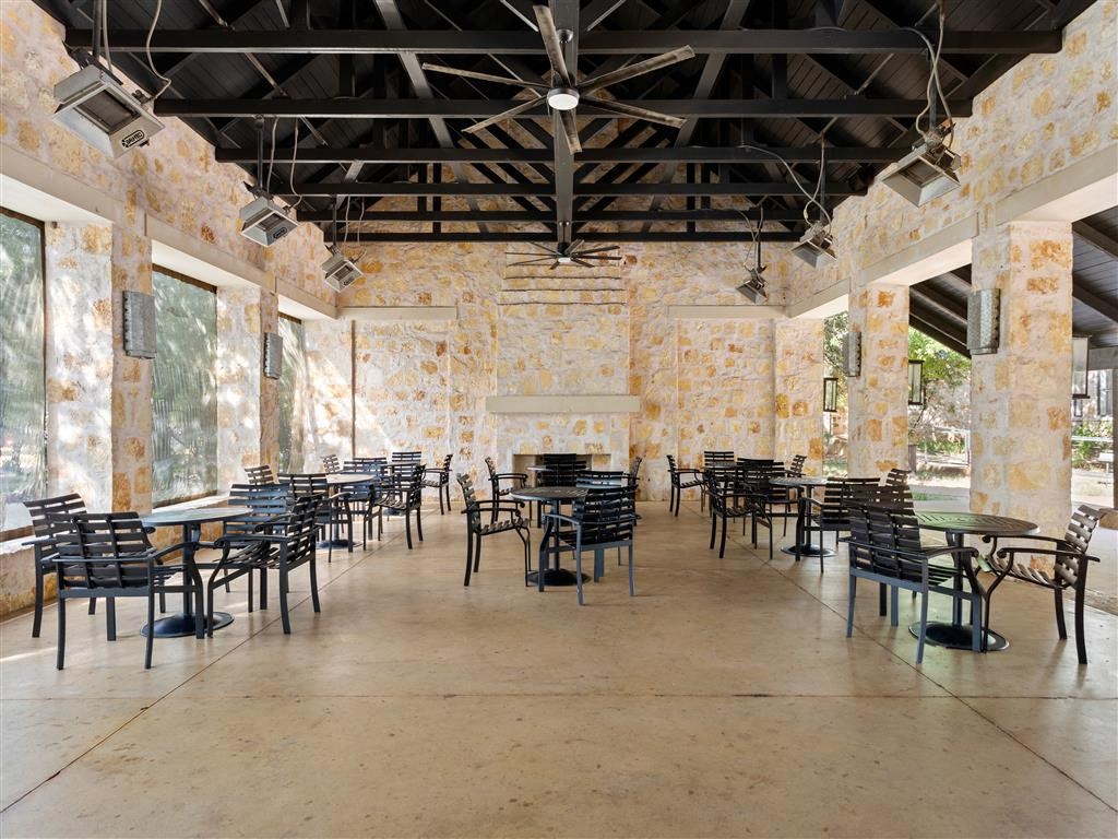 a restaurant with tables and chairs in a room with stone walls