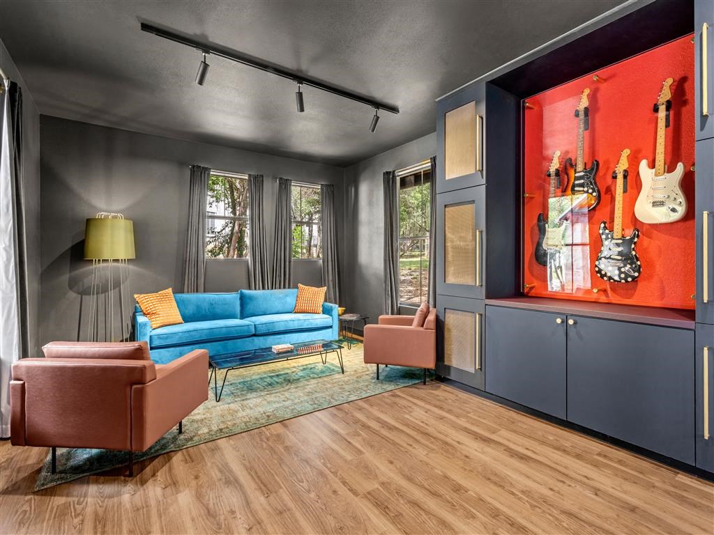 a living room with a blue couch and guitars on the wall