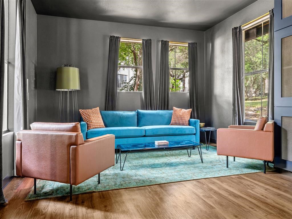 a living room with a blue couch and two chairs