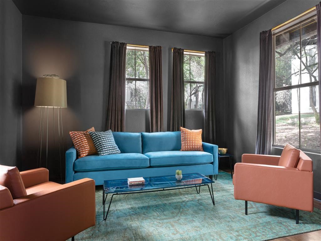 a living room with a blue couch and brown chairs