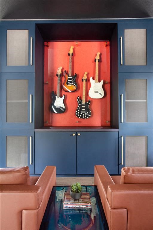 a living room with guitars hanging on the wall