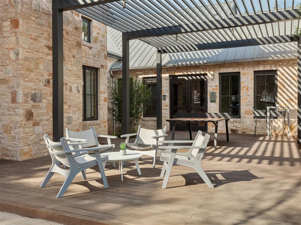 a patio with tables and chairs under a pergola