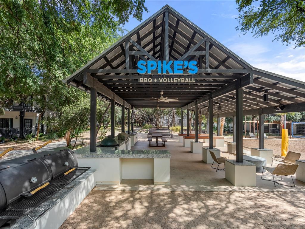 a pavilion with tables and chairs in a park