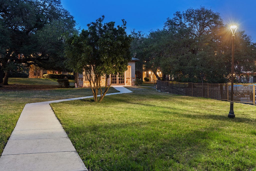 the front yard of a house with a sidewalk and trees