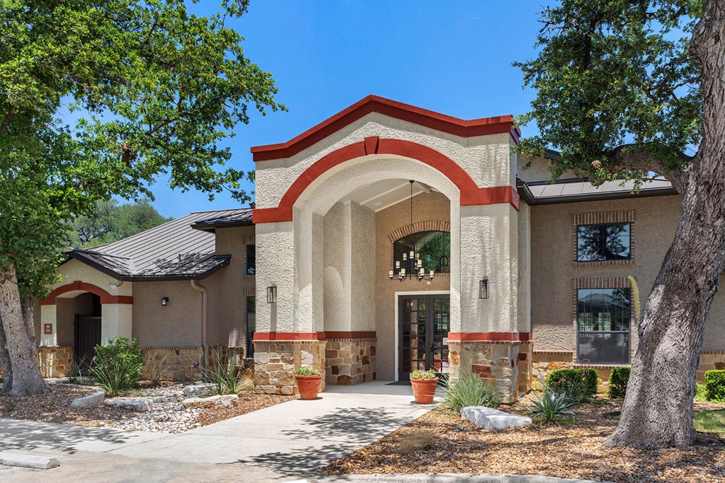 the front of a house with trees and a sidewalk