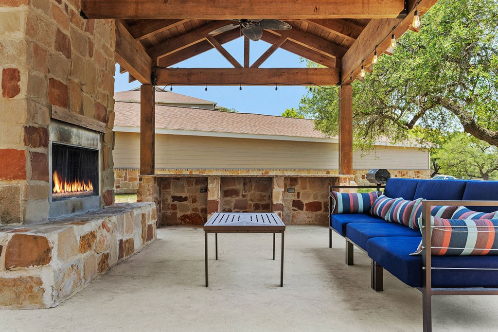 a covered patio with a fireplace and couches