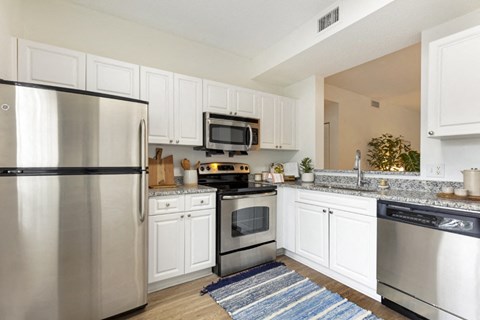 a kitchen with stainless steel appliances and white cabinets