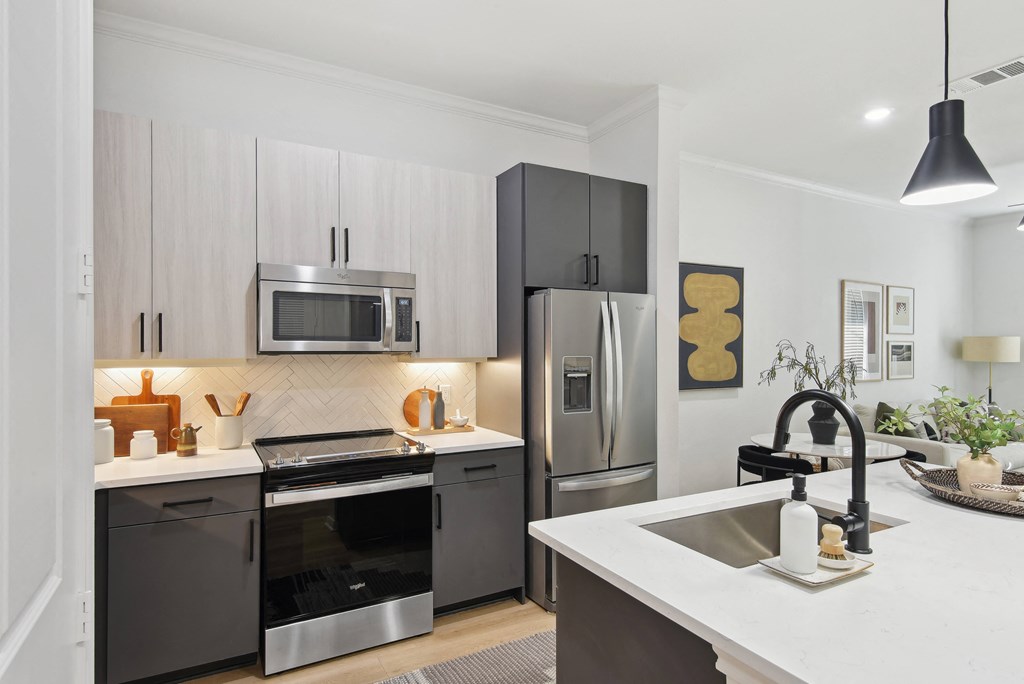 a modern kitchen with stainless steel appliances and white counter tops