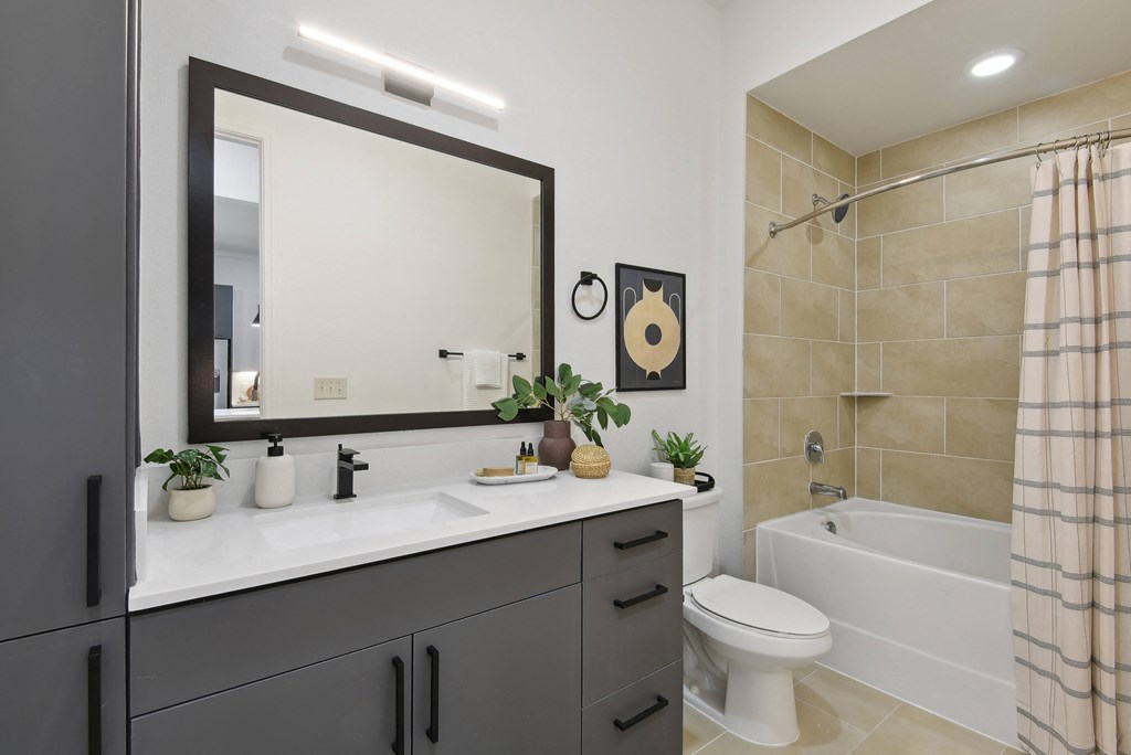 a bathroom with a large mirror and a toilet and a shower