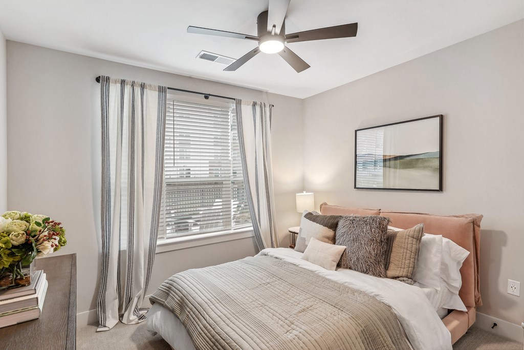 a bedroom with a bed and a ceiling fan