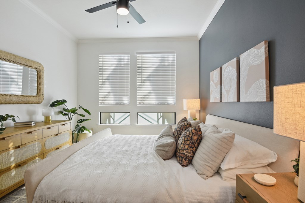 a bedroom with a large bed and a ceiling fan