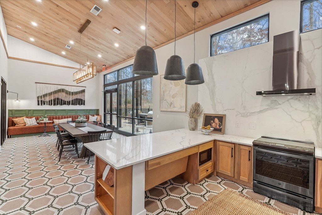 the kitchen has a large island and a dining room with a table and chairs