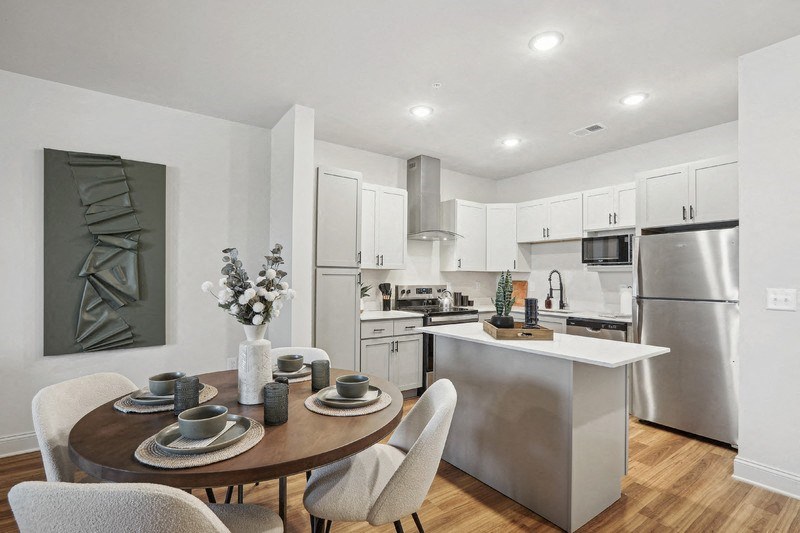 A modern kitchen with a dining table set for two.