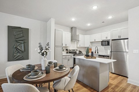 A modern kitchen with a dining table set for two.