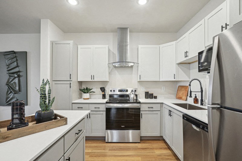 A modern kitchen with stainless steel appliances and white cabinets.