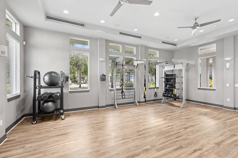 A spacious home gym with wooden floors and various exercise equipment.
