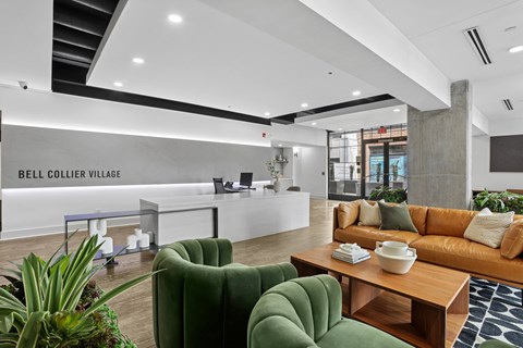 Bell Collier Village reception area with a green sofa and a wooden table.