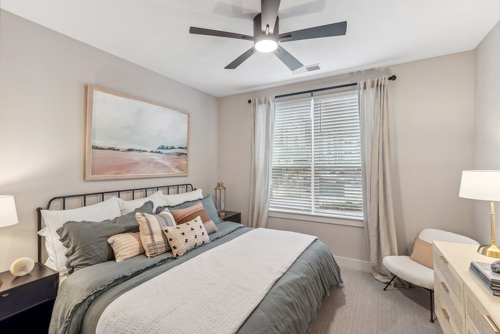 a bedroom with a large bed and a ceiling fan