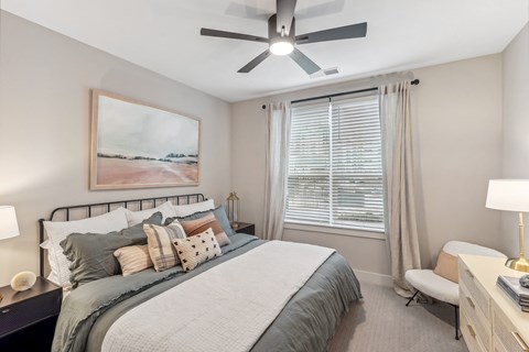 a bedroom with a large bed and a ceiling fan