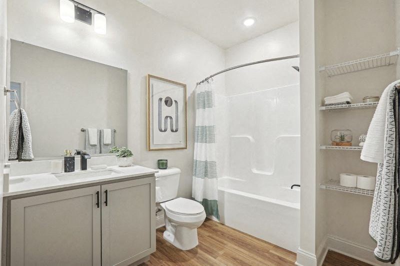 A bathroom with a toilet, sink, and shower.