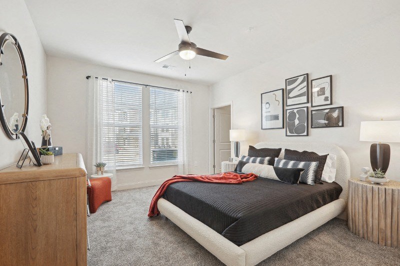 A bedroom with a large bed and a wooden dresser.