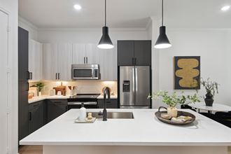 a kitchen with black and white cabinets and a white counter top