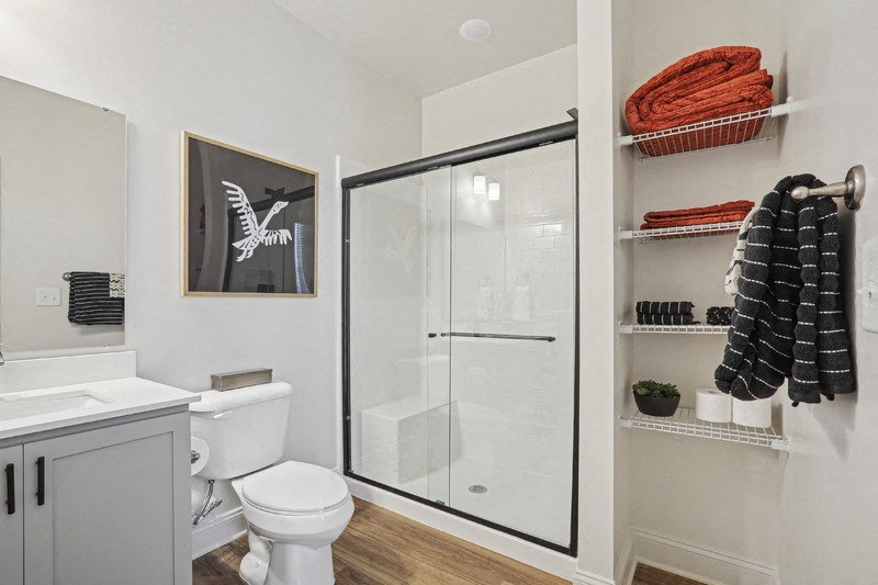 A white toilet sits next to a white sink in a bathroom.