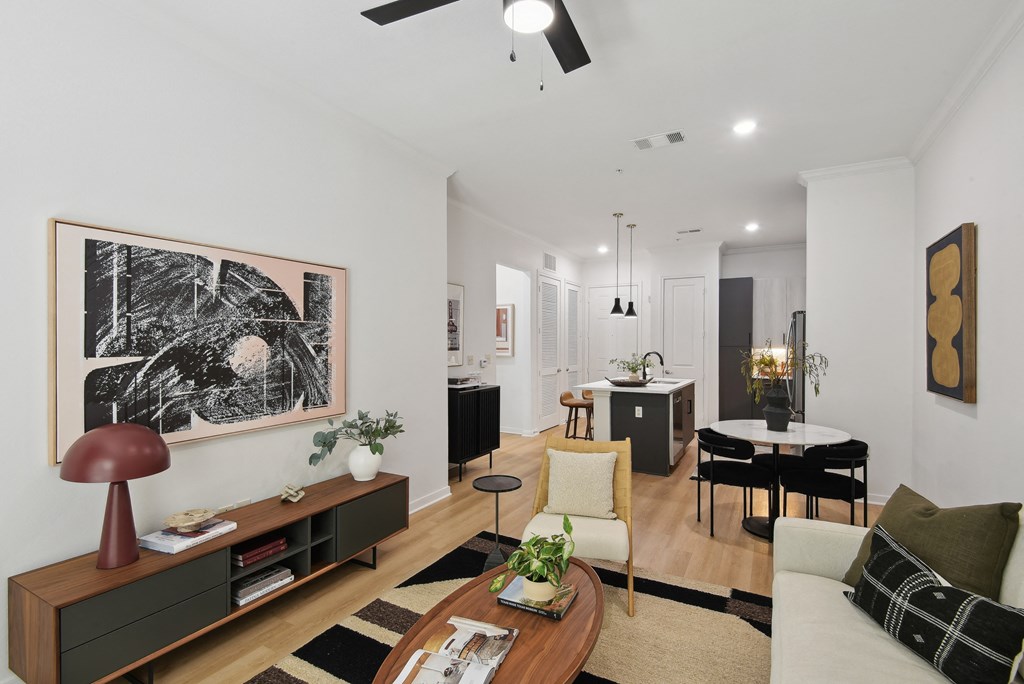a living room with a couch and a table and a kitchen with a dining room