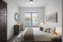 a white bedroom with a large bed and a window