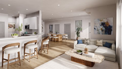 A modern living room with a kitchen area in the background.