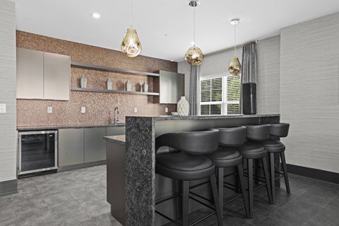 A modern kitchen with a bar area and stools.