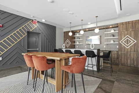 A modern entertainment lounge with a wooden table and chairs.