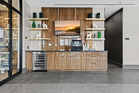 A coffee bar with wooden cabinets and a marble floor.