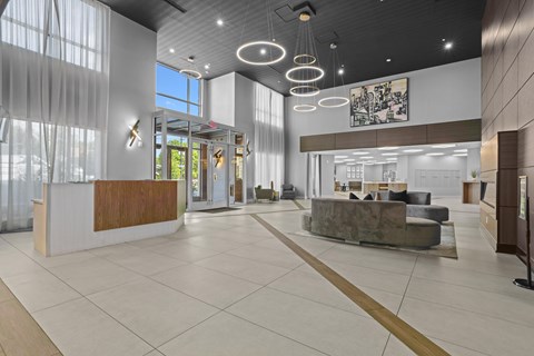 A reception area with a white tile floor and a large wooden reception desk.
