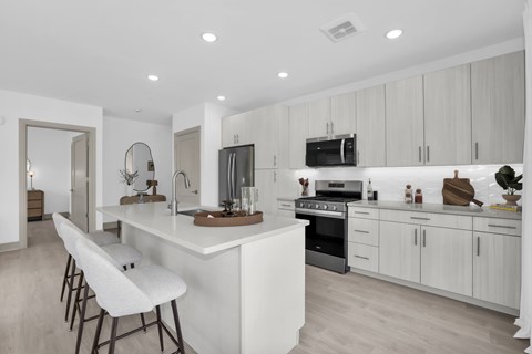 A modern kitchen with white cabinets and a large island.