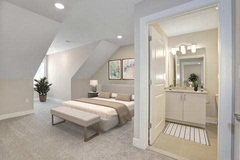 A bedroom with a bed, nightstand, and a mirrored cabinet.