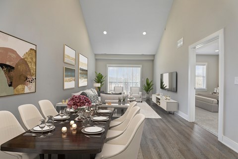 A modern dining room with a long table set for a meal.