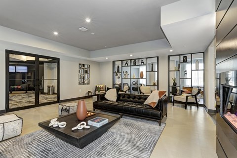 A resident lounge with a black couch and a coffee table.