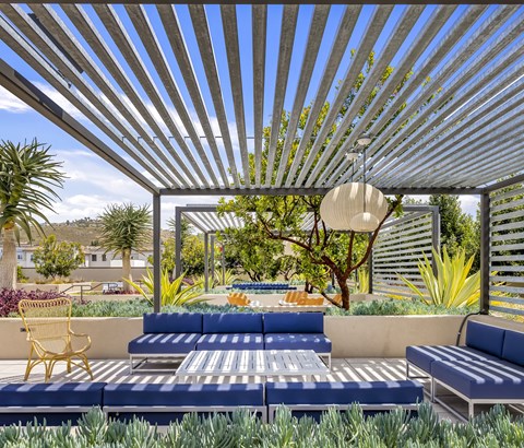 A blue and white striped patio with a yellow chair and a hanging light.